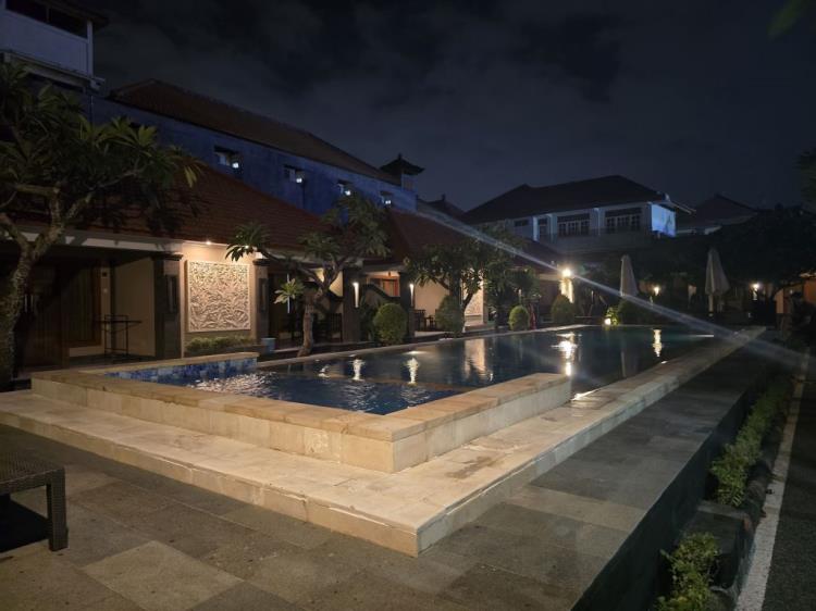 ilustración con IA: Gora Beach Inn en Kuta: buena ubicación y piscina grande, pero habitaciones básicas, Wi-Fi débil y baño anticuado
